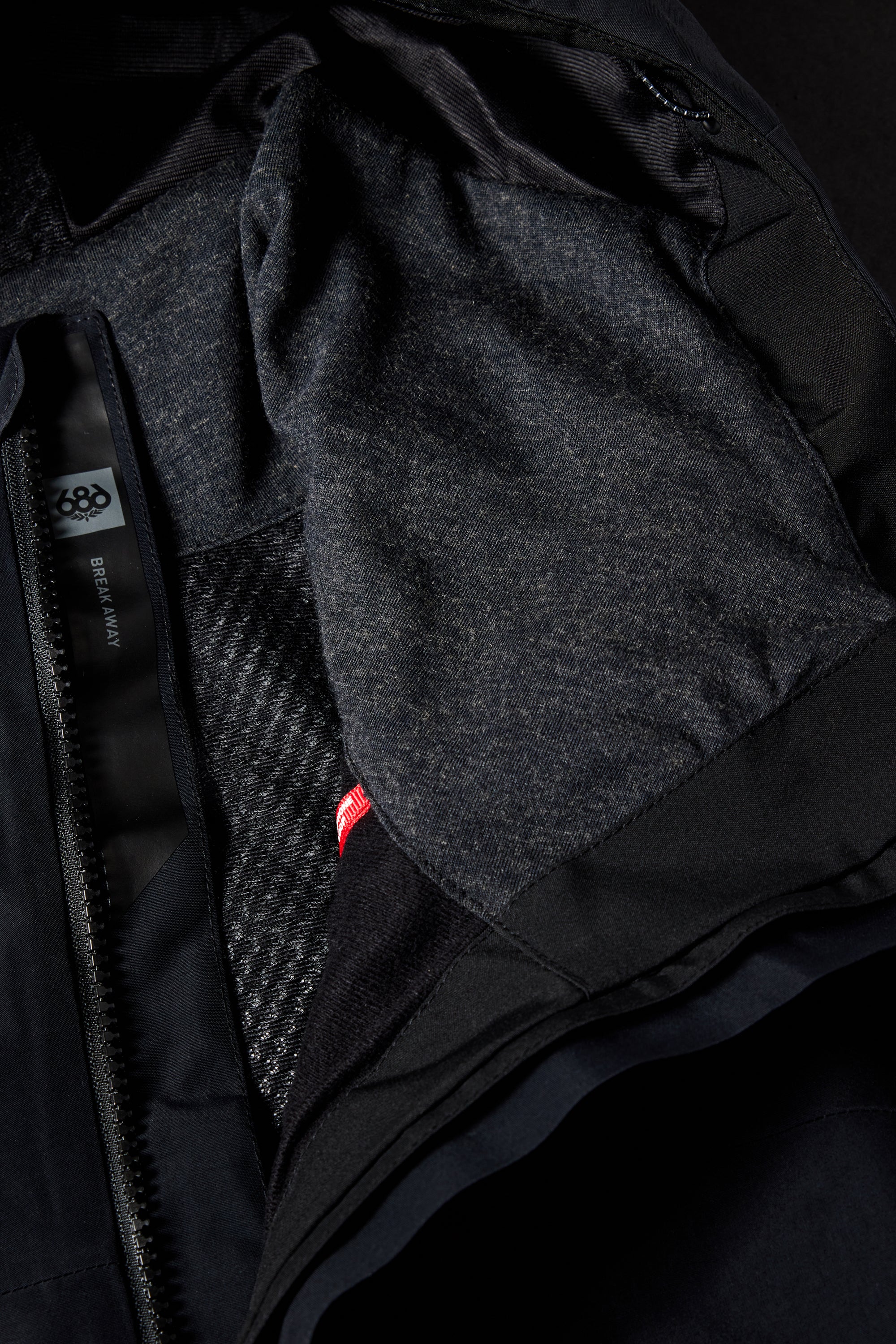 The 686 brand offers a black women's Gore-Tex Skyline shell jacket with a red zipper.