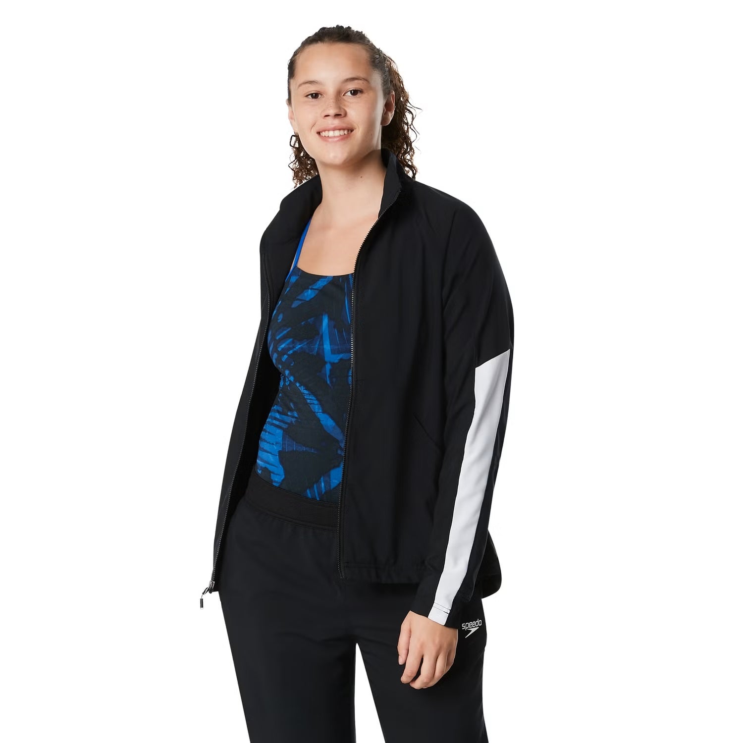 Speedo Women's Edge Warm Up Jacket - A black jacket with a blue logo on the left chest and two zippered pockets on either side.