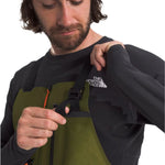 North Face Men's Ceptor Shell Bib - A man wearing a black and green bib with orange accents, featuring a white logo on the chest.