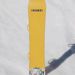 Burton Process Board Flying V Snowboard 2025 - A yellow snowboard with a rounded tip and two small loops on either side of the board near the top.