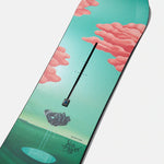 Burton Women's Yeasayer Snowboard 2025 - A green snowboard with a pink cloud design on top of a mountain landscape.