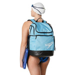 Speedo Teamster 2.0 Swim Backpack - A light blue backpack with a zippered main compartment and two side pockets, featuring black trim and straps.