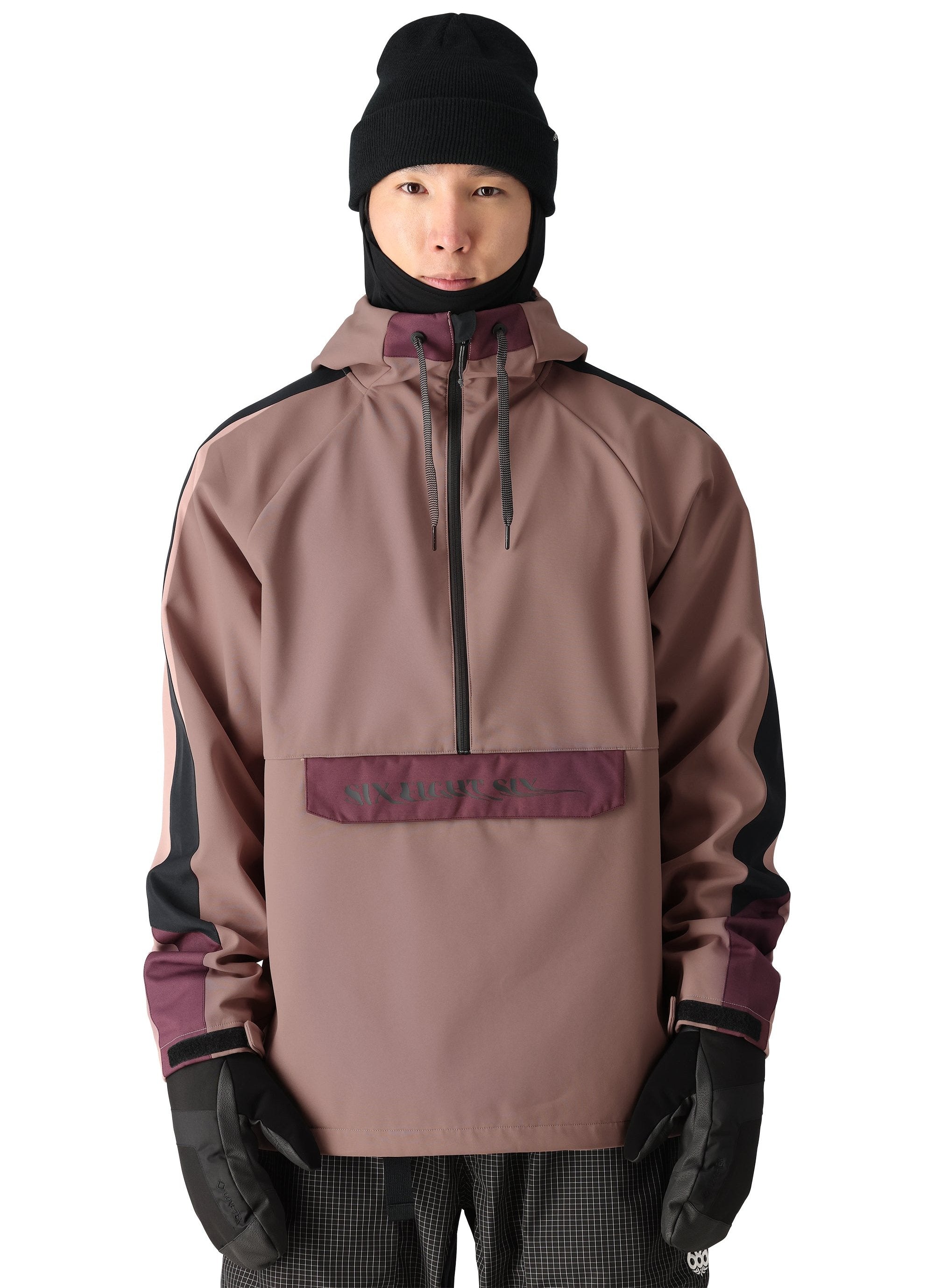 The 686 brand's waterproof anorak jacket has a light brown body with dark purple accents on the shoulders and upper arms.