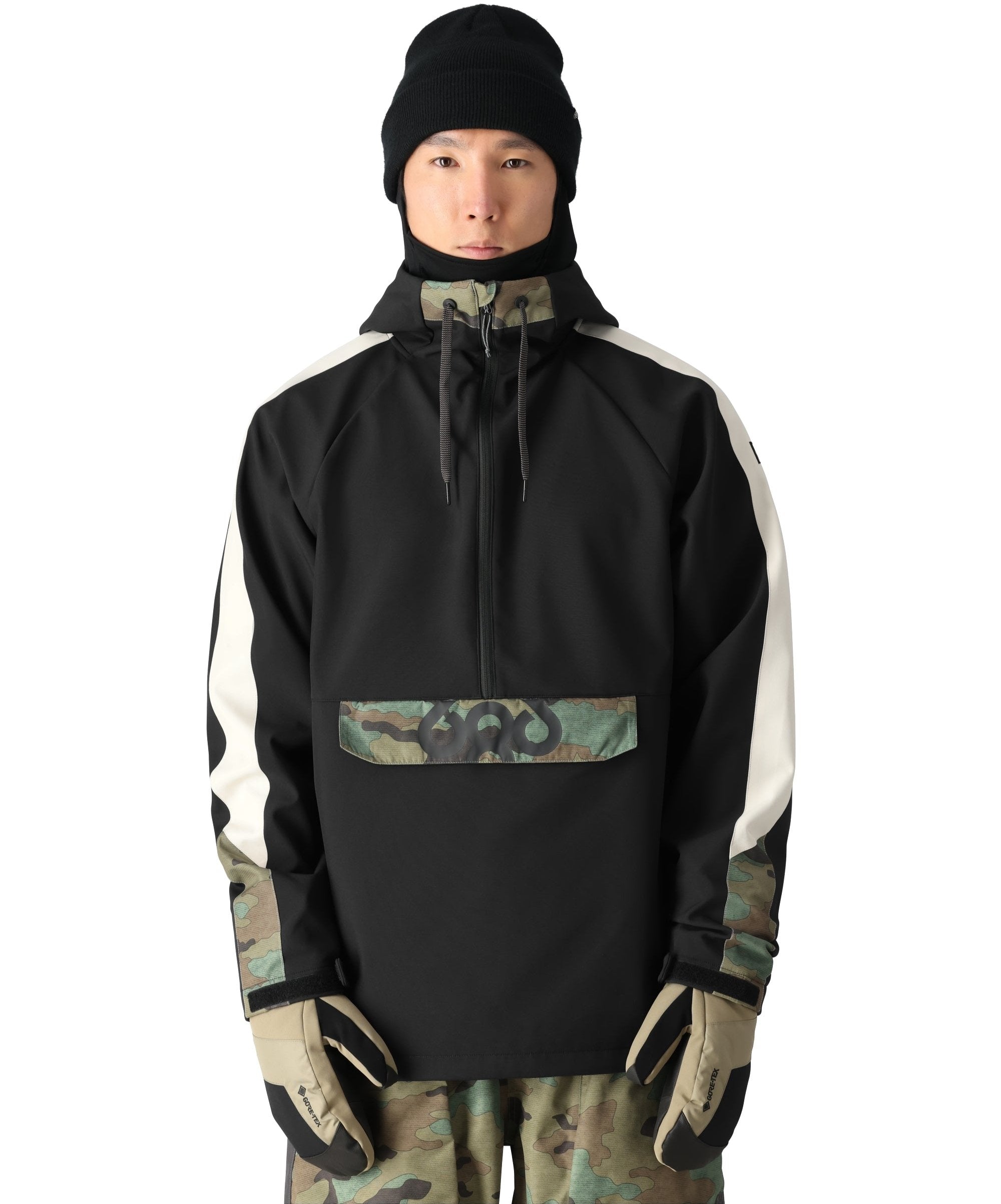 The 686 Waterproof Anorak Jacket appears in black with white stripes on both sides and camouflage accents around the chest pocket.