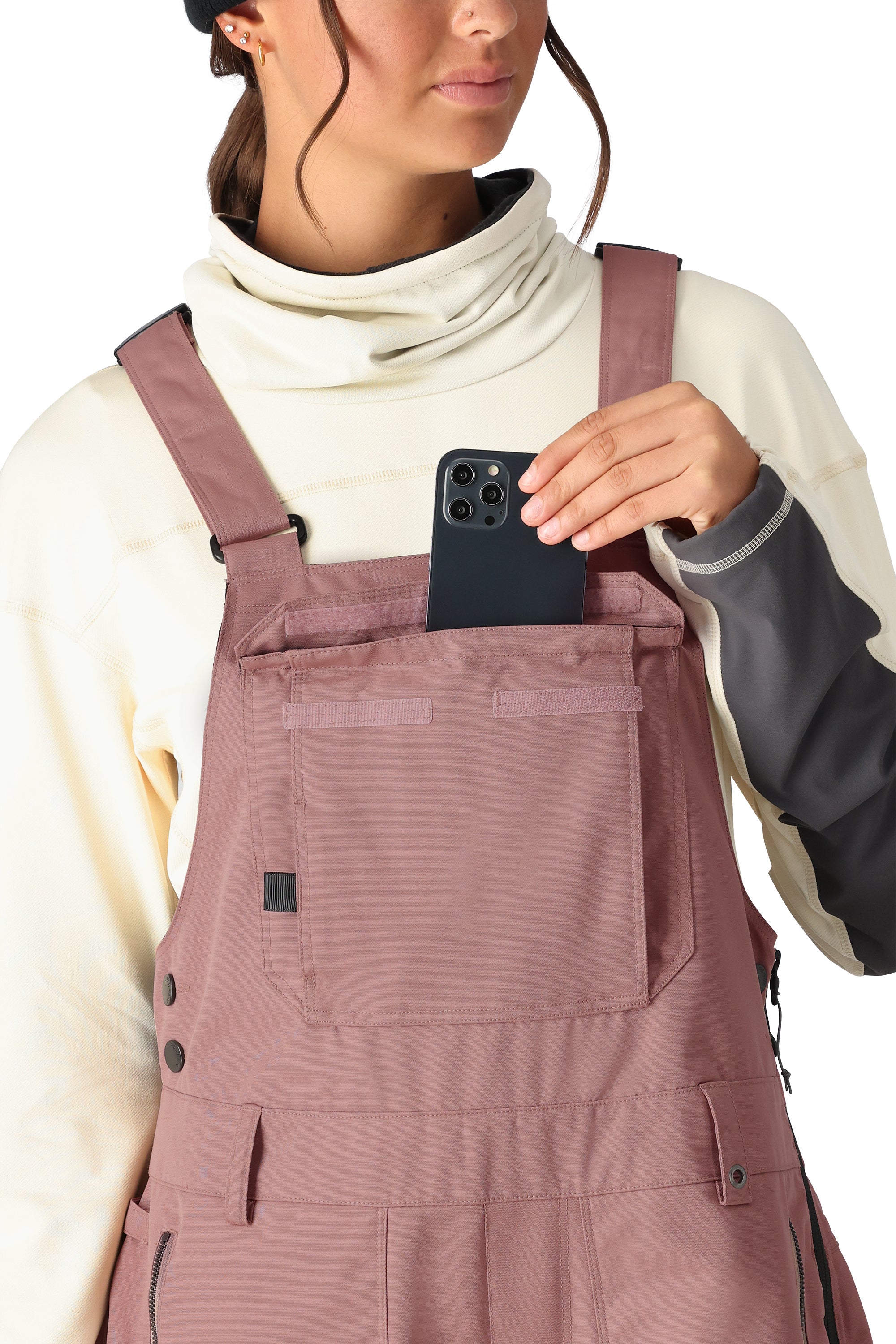 The 686 Black Magic bib overall in black has an insulated hood and front zip closure.