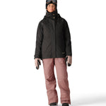 The 686 Black Magic insulated bib features a black color and appears to be worn by a woman in a front view.