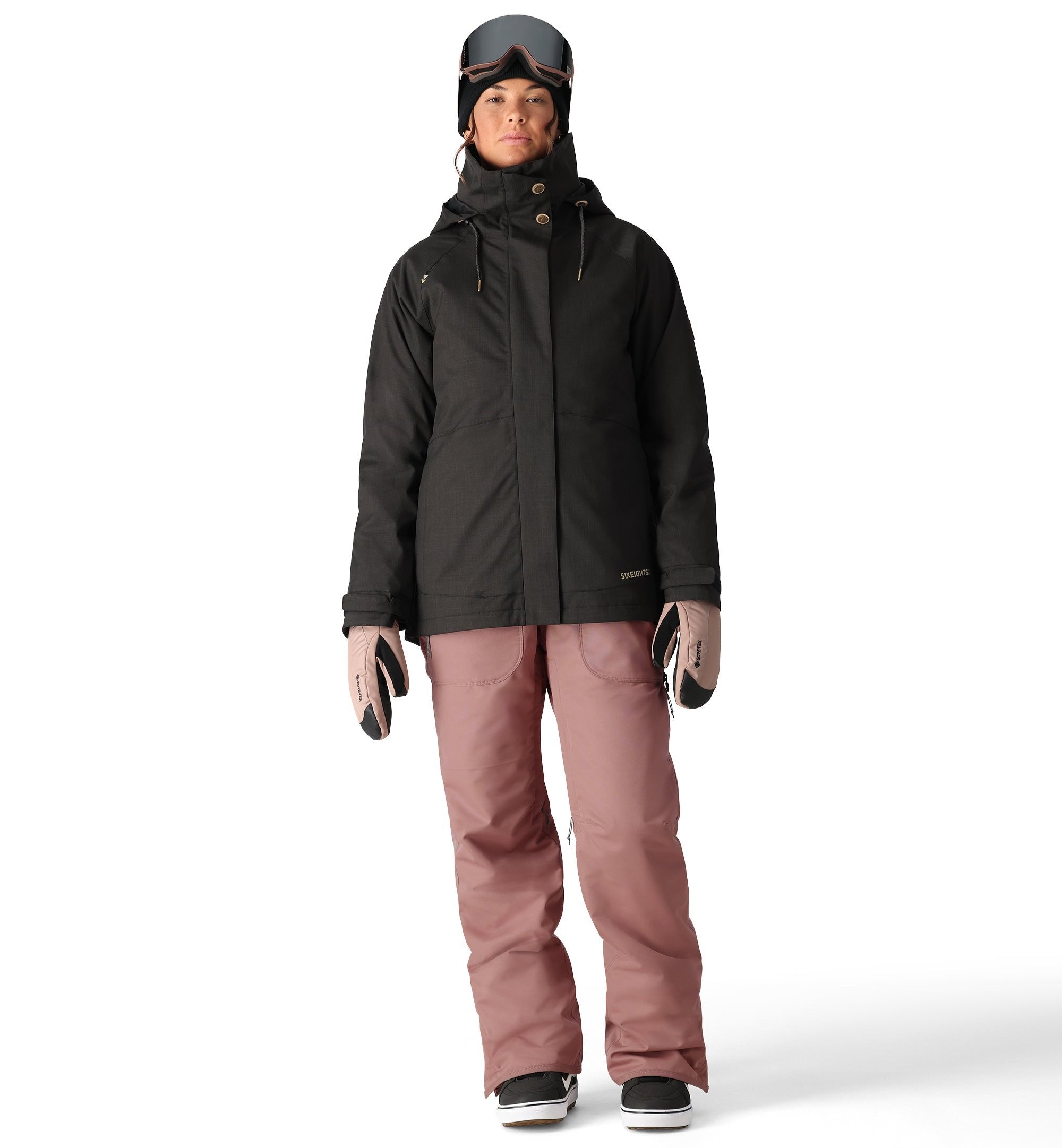 The 686 Black Magic insulated bib features a black color and appears to be worn by a woman in a front view.