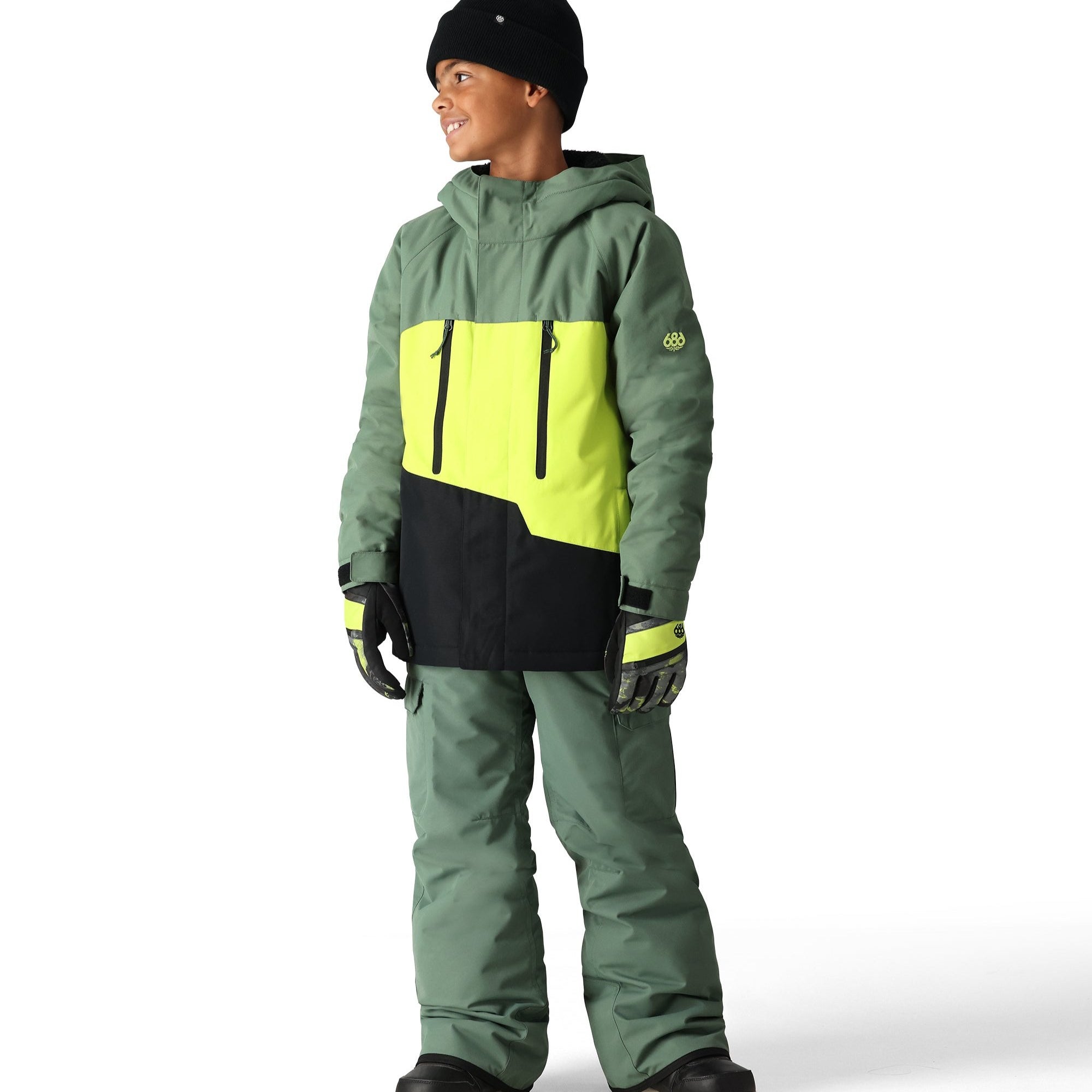 The 686 Youth GEO Insulated Jacket 2025 is predominantly sage green with a neon yellow and black geometric design on the front.