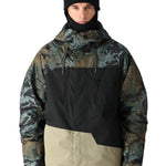 The 686 Geo Insulated Jacket in camouflage pattern has a black front panel and tan accents.