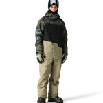 The 686 Geo Insulated Jacket 2025 has a black and green camouflage pattern with a high collar and a zippered chest pocket.