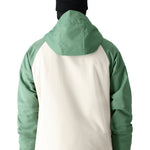 The 686 brand's Geo Insulated Jacket 2025, visible from the back, has a cream-colored panel on both sides and green sleeves.