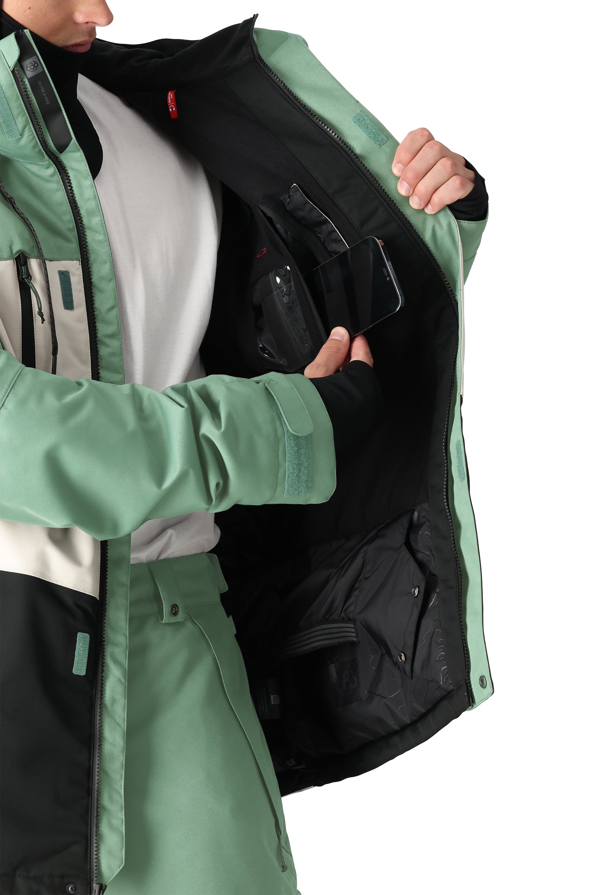 The 686 Geo Insulated Jacket 2025 is green with an insulated hood and zippered pockets.