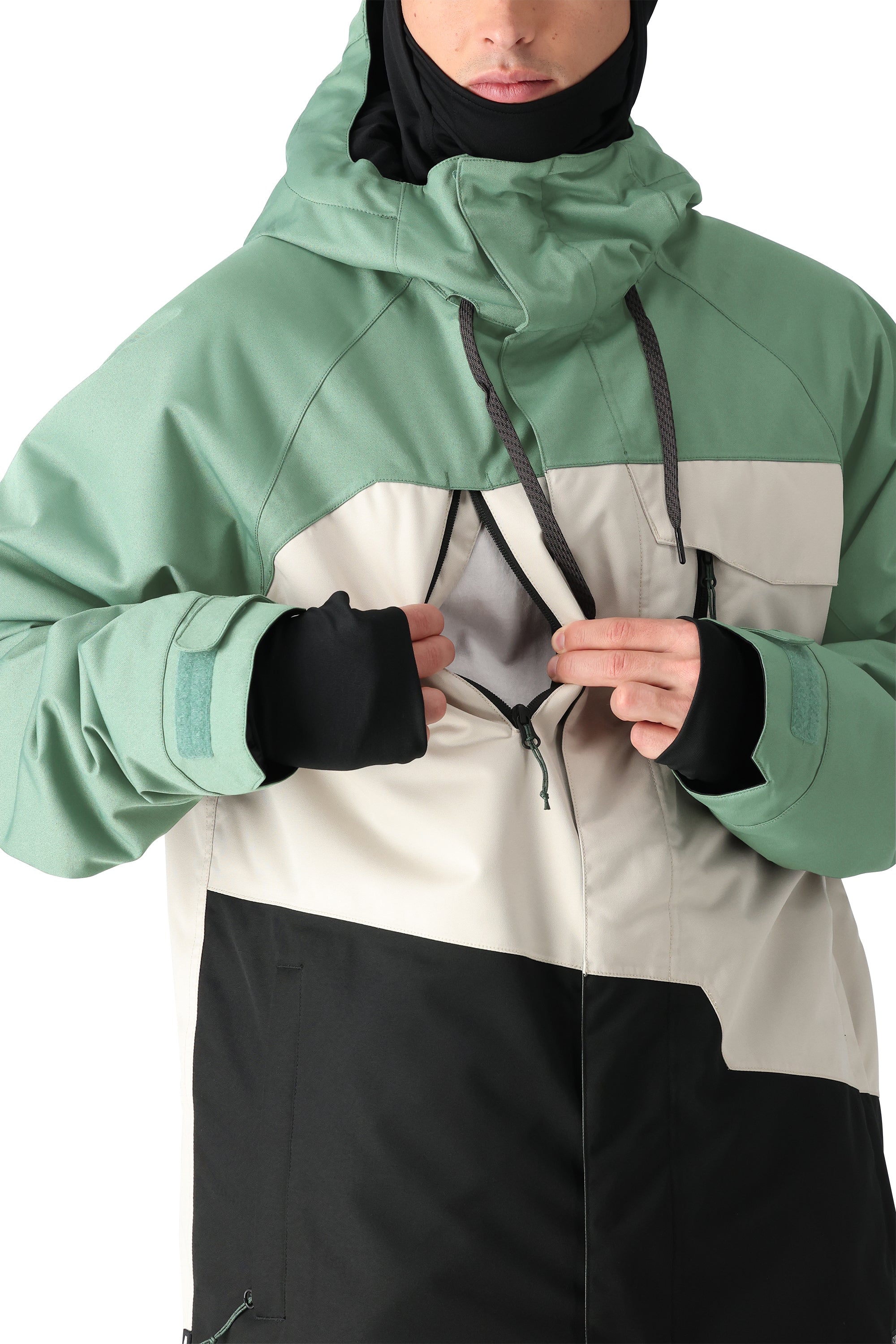 The 686 Geo Insulated Jacket 2025 has a predominantly green color scheme with a white panel on the front and black accents, featuring a drawstring hood and zippered pockets.
