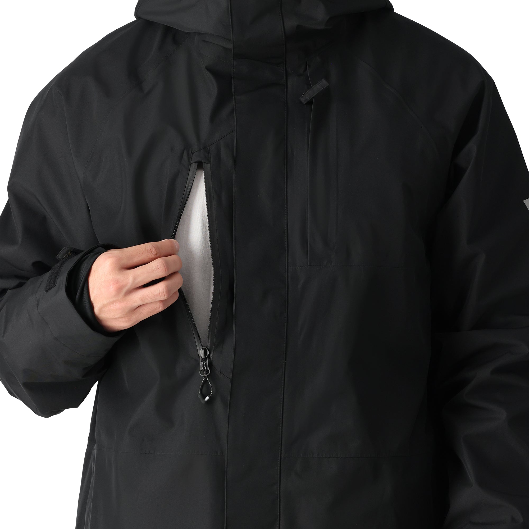 The 686 GORE-TEX Core Shell Jacket 2025 is black with a white fleece lining visible through the zipper and has a high collar.