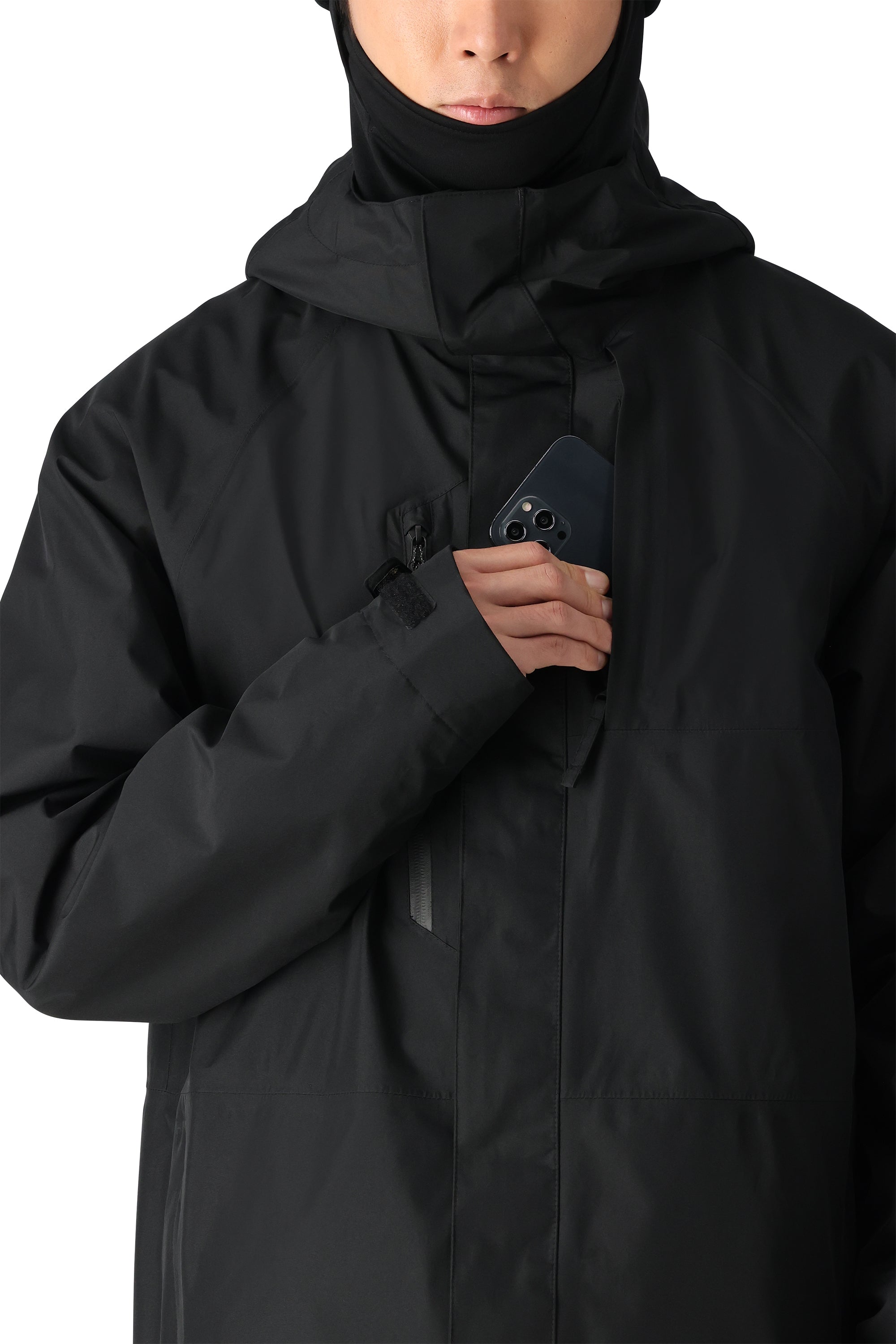 The 686 Gore-Tex Core Shell Jacket 2025 in black has an insulated hood and appears to be zipped up on a model.