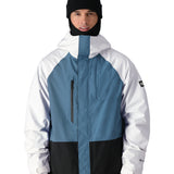 The 686 Gore-Tex Core Shell Jacket in black and white has a blue panel on the chest area with two zippered pockets.