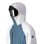 The 686 Gore-Tex Core Shell Jacket 2025 is predominantly white with blue and black accents on the front.