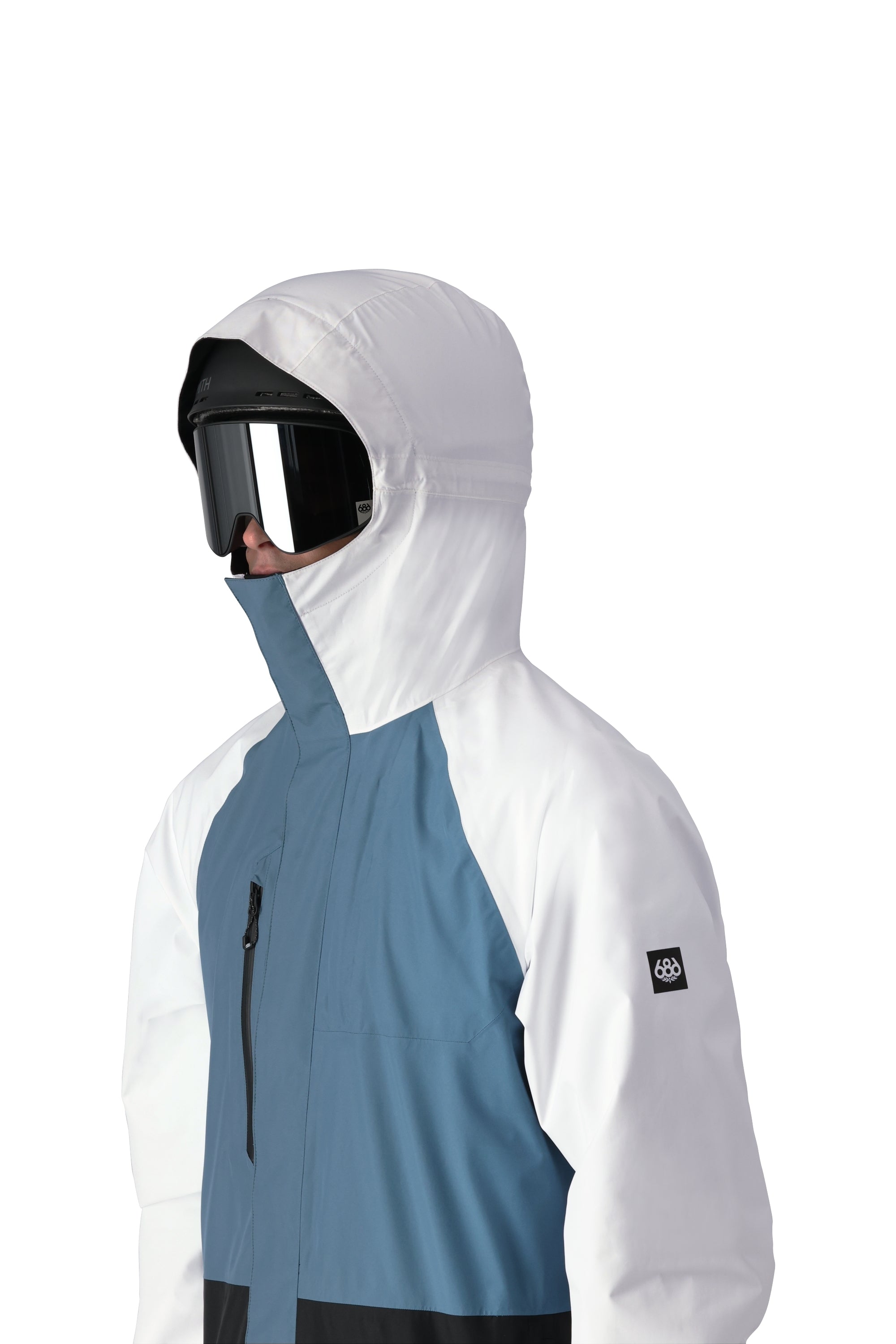 The 686 Gore-Tex Core Shell Jacket 2025 is predominantly white with blue and black accents on the front.