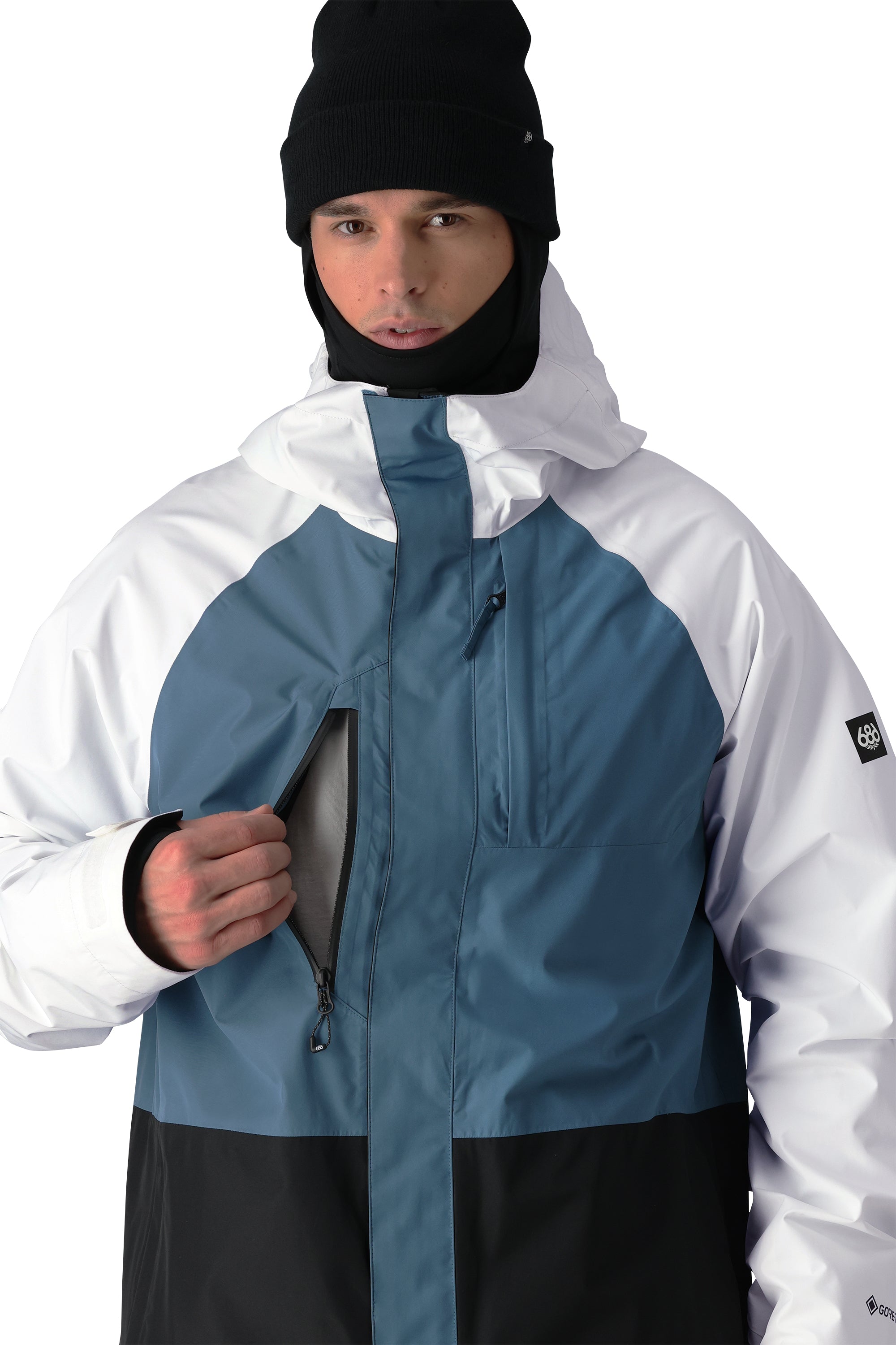 The 686 Gore-Tex Core Shell Jacket 2025 has a white front with blue detailing and black accents.