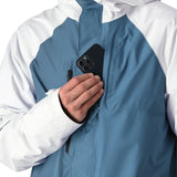 The 686 Gore-Tex Core Shell Jacket 2025 is predominantly blue and white, with a black panel at the bottom.