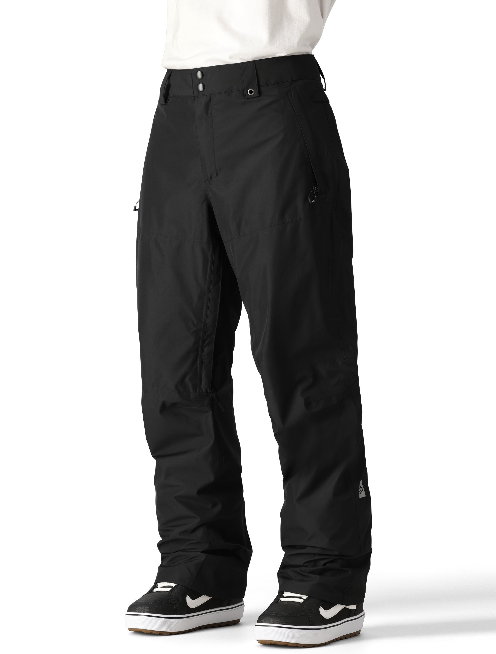 The 686 Men's GORE-TEX Core Shell Pant 2025 is primarily black with silver accents and a zippered pocket on the right thigh.