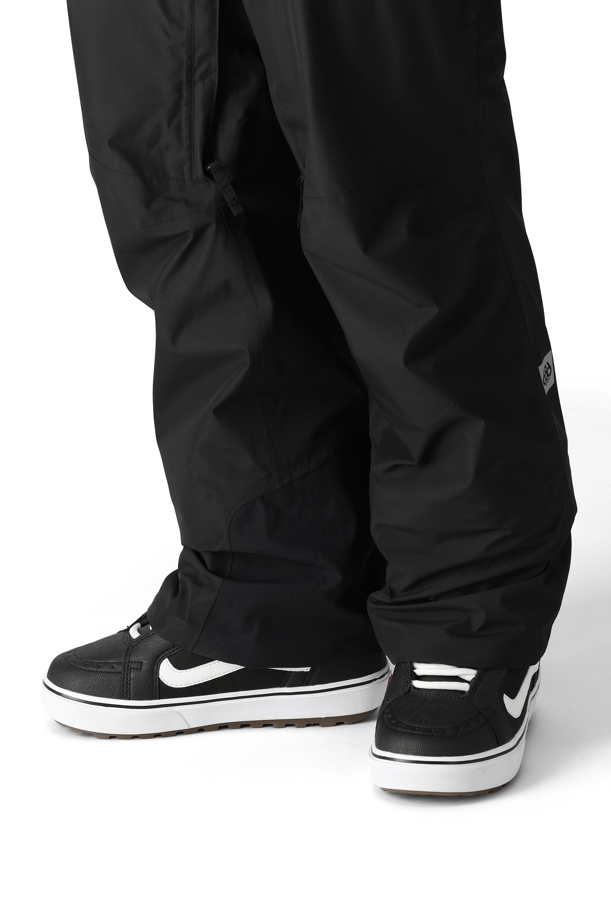 The 686 Men's GORE-TEX Core Shell Pant 2025 is primarily black with white logos and zippers.