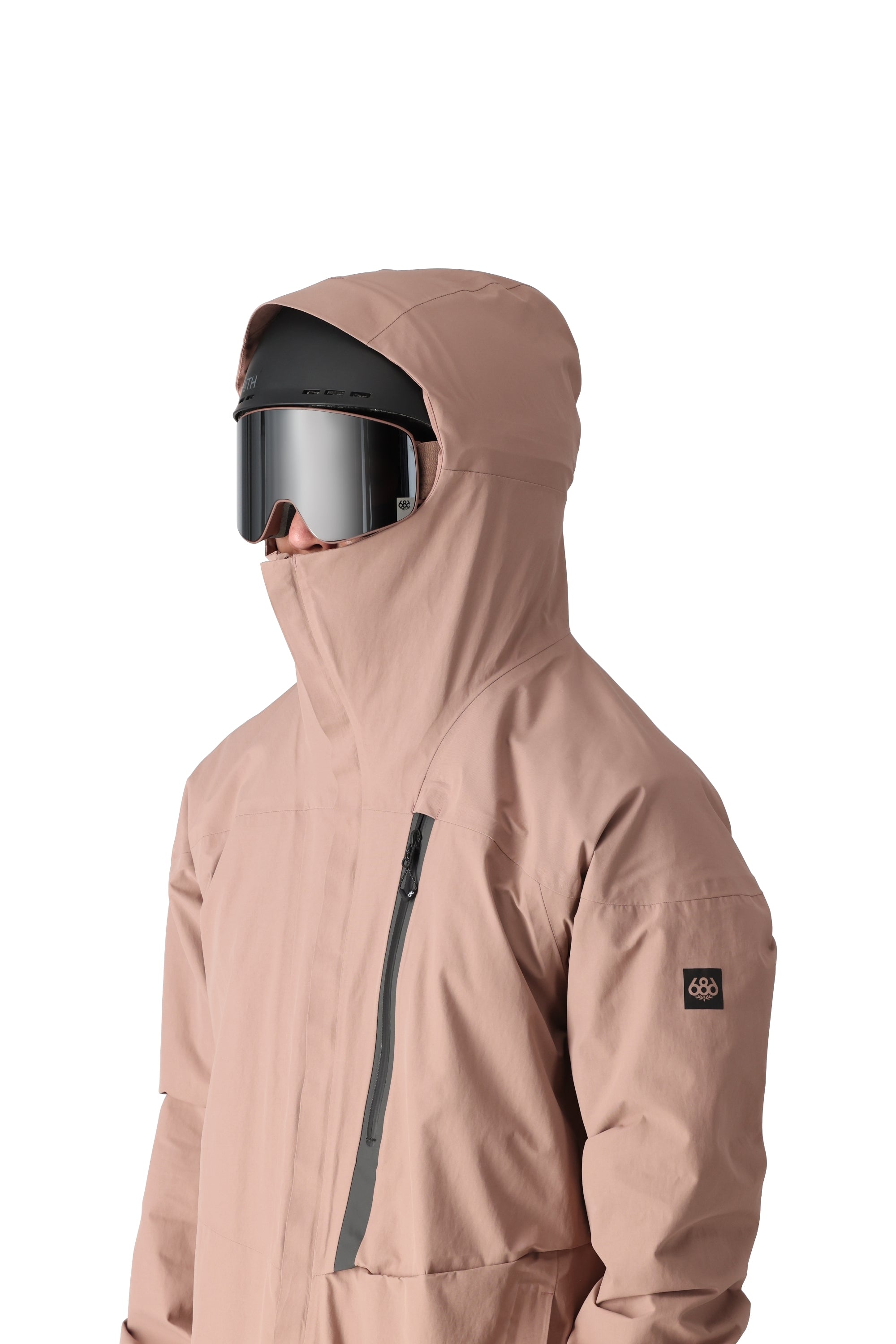 The 686 Gore-Tex GT shell jacket in tan has a full-length zipper and an insulated hood.