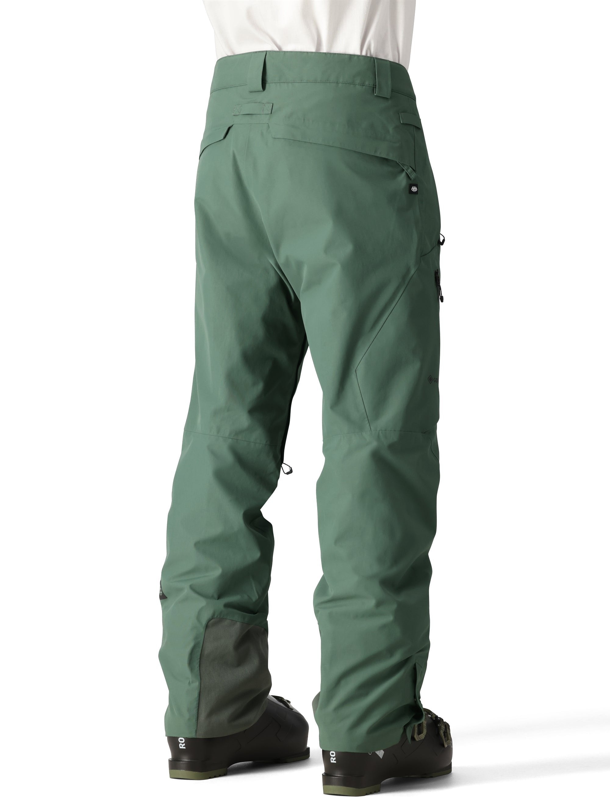 The 686 Men's GORE-TEX GT Pant 2025 is depicted in a green color with a black stripe on the left leg and two zippered pockets.