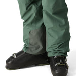 The 686 Men's GORE-TEX GT Pant 2025 appears in a front view with a dark green color and grey patch on the leg.