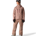 The 686 Women's GORE-TEX Skyline Shell Jacket 2025 is primarily tan with a dark pink zipper and logo.