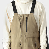 The 686 Men's GORE-TEX Stretch Dispatch Bib 2025 is primarily khaki with black accents and adjustable BOA dials on the bib straps.