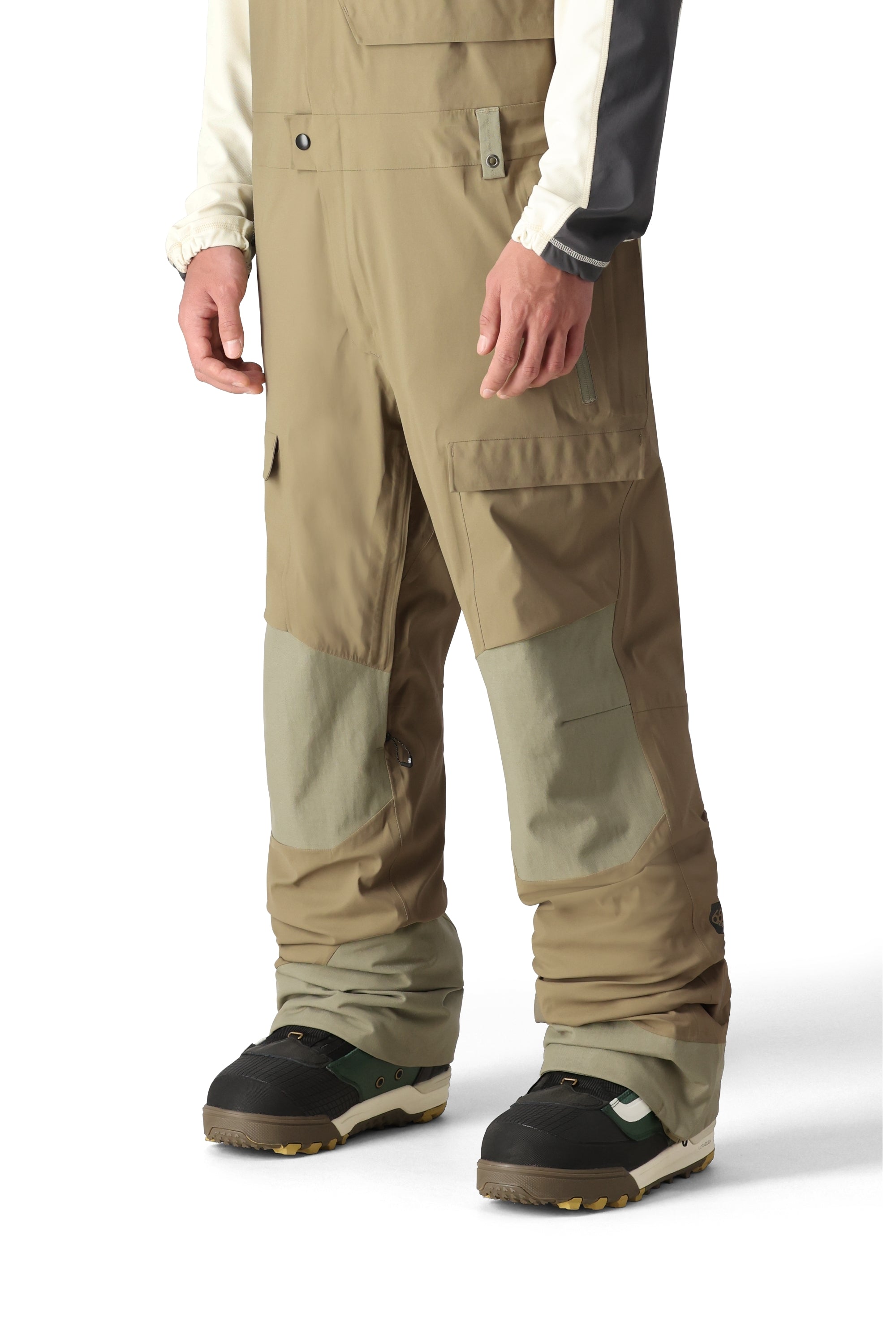The 686 Men's GORE-TEX Stretch Dispatch Bib features a light brown color with tan accents and is shown in a front view.