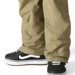 The 686 Women's GORE-TEX Willow Insulated Pant 2025 is shown in khaki with a zippered side pocket and adjustable waistband.