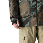 The 686 Hydra Thermagraph Jacket 2025 has a camouflage print in shades of green and brown.