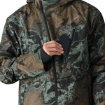 The 686 Hydra Thermagraph Jacket 2025 has a camouflage pattern with shades of green and brown on a black base.