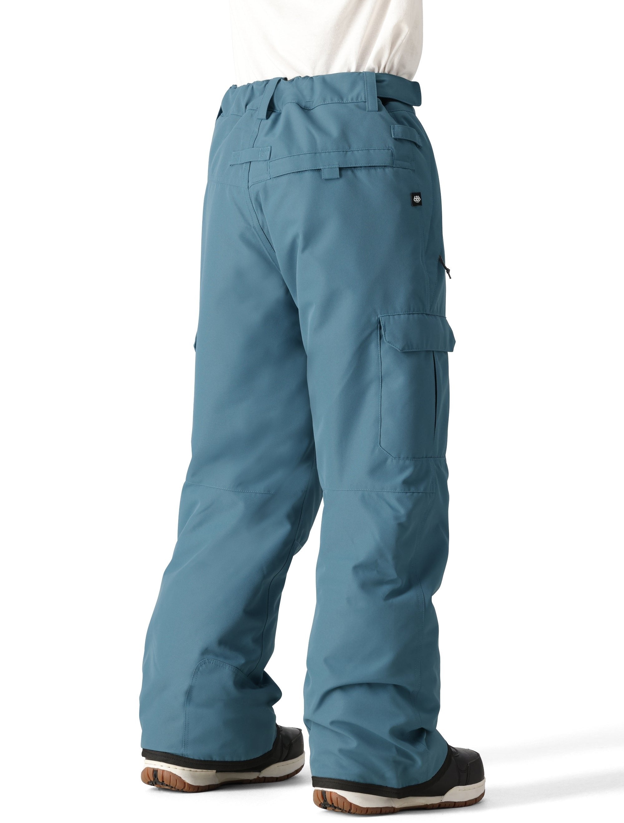 The 686 Boy's Infinity Cargo Insulated Pant 2025 is shown from the back in teal with two cargo pockets and a belt.