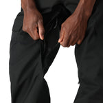 The 686 Men's Infinity Insulated Cargo Pant 2025 is shown in black with zippered pockets and cargo-style leg openings.