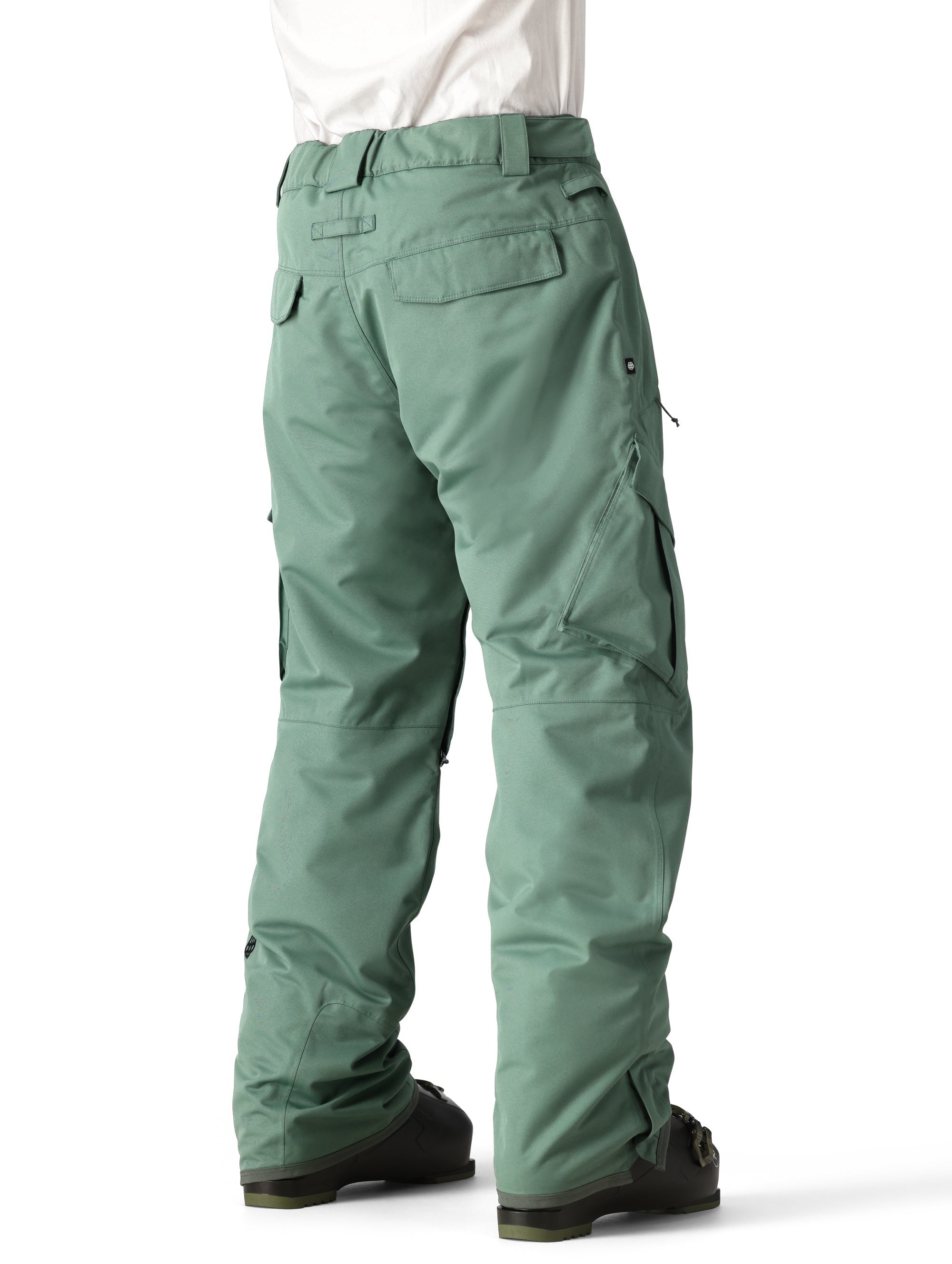 The 686 Men's Infinity Insulated Cargo Pant 2025 is shown in a dark green color with a belt loop at the waist and two zippered cargo pockets on each thigh.