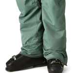 The 686 brand pant has a dark green color with two zippered cargo pockets and adjustable cuffs.