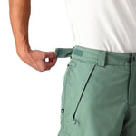The 686 Men's Infinity Insulated Cargo Pant 2025 appears to be a light green pair of pants with cargo pockets and an adjustable waistband on the front view.