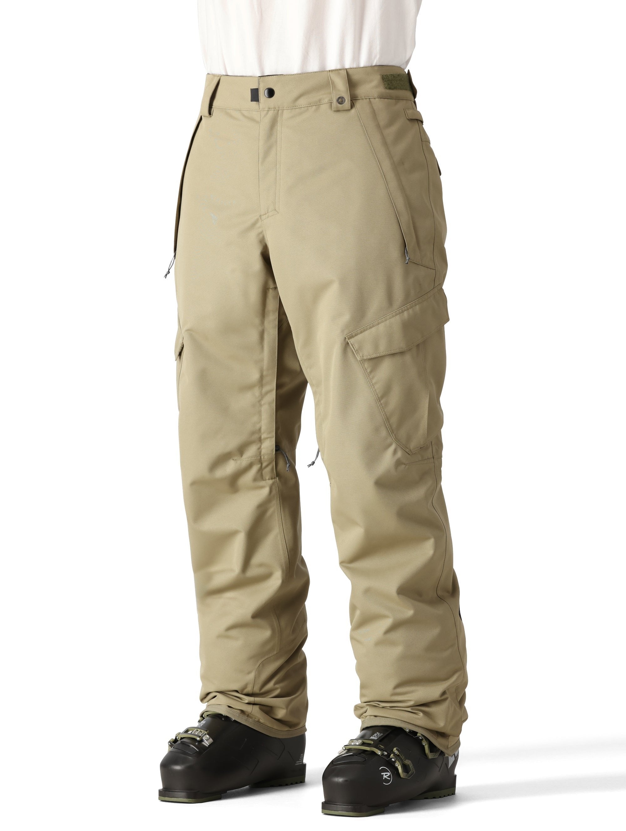 The 686 Men's Infinity Insulated Cargo Pant 2025 is primarily khaki with black accents and a zippered pocket on the right thigh.