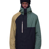 The 686 Gore-Tex Core Shell Jacket in black, tan, and green has a zippered front with two front pockets under a hood.