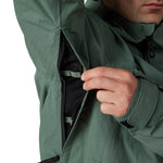 Men's green shell jacket close-up: front zip and pocket detail, drawstring hem