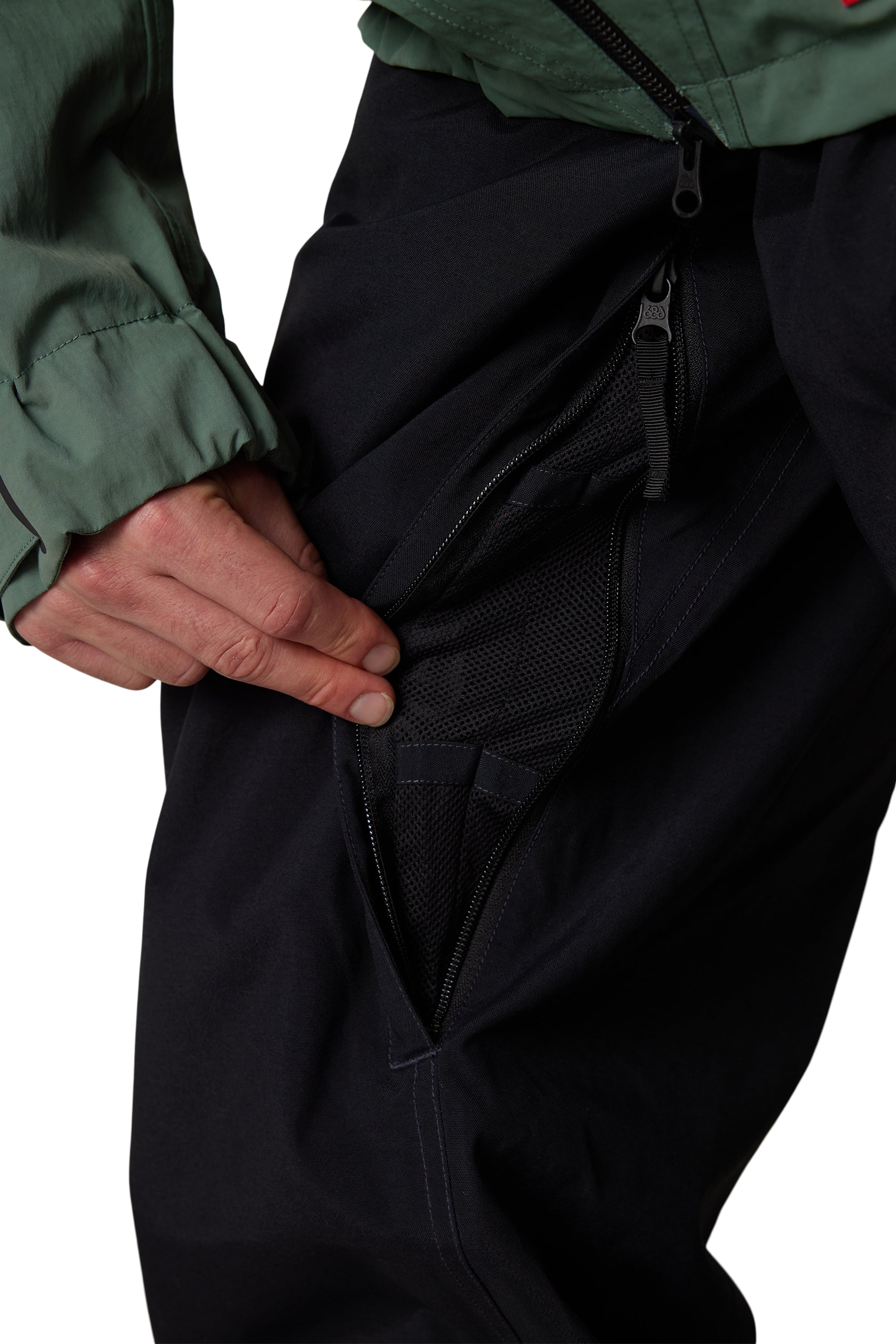 Men's black shell pants close-up of zip hand pocket with mesh lining