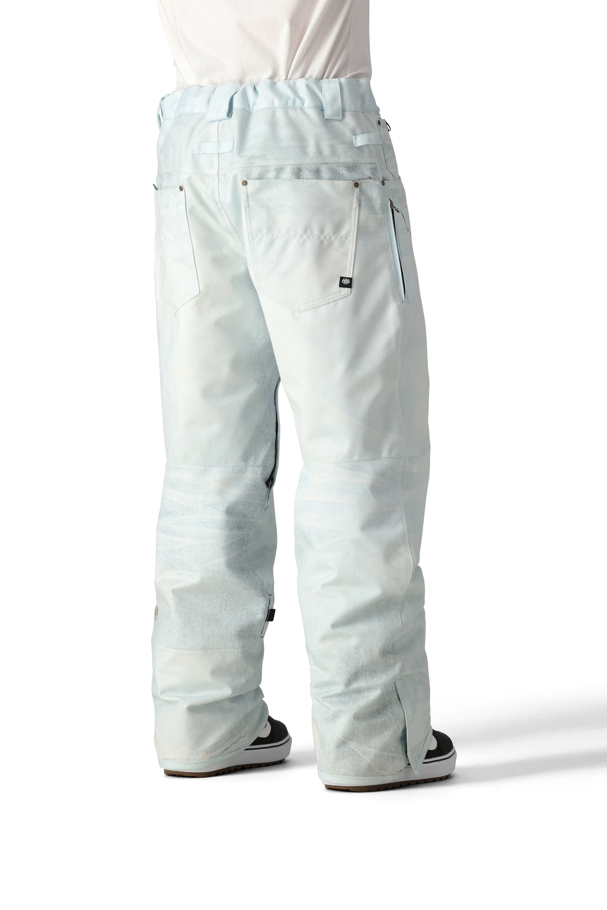 The 686 Deconstructed Denim Insulated Pant 2025 is light blue with an adjustable waistband and zippered pockets.