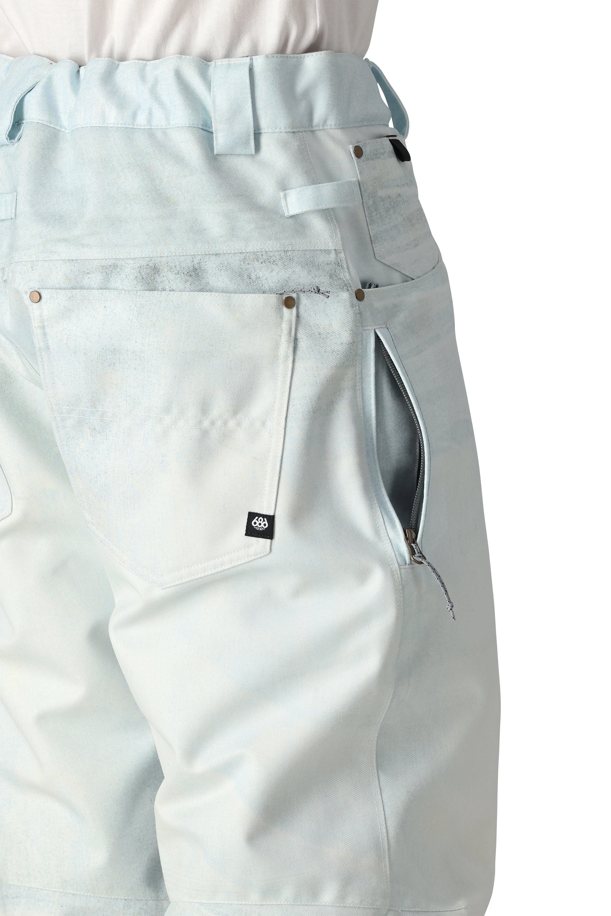 The 686 Deconstructed Denim Insulated Pant 2025 appears to be light blue with an insulated hood and a zipper on the side.