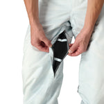 The 686 Deconstructed Denim Insulated Pant 2025 has a light blue color with a distinctive black and white striped pattern on the side view.