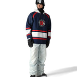 The 686 Deconstructed Denim Insulated Pant 2025 is shown from the front in light blue with red stripes and a white stripe across the waistband.