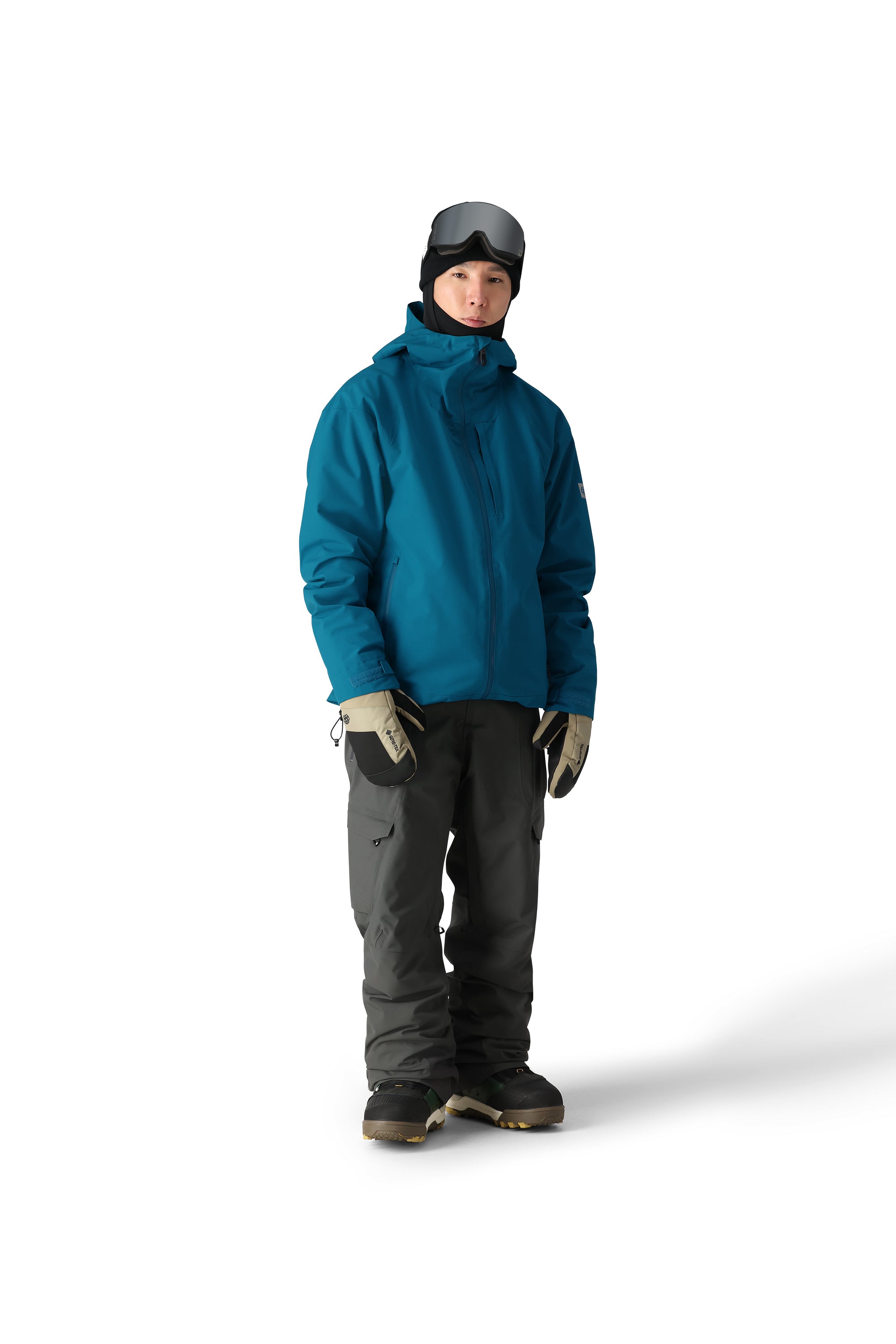 The 686 Gateway Shell Jacket 2025 is primarily blue-green with black accents and has an adjustable hood.