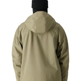 The 686 Gateway Shell Jacket 2025 in khaki has an oversized hood and two zippered pockets on the front.